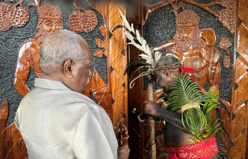 Head of State Nikenike Vurobaravu (left) and the President of the Malvatumauri Council of Chief, Ravun Merhimba DangDang, open the doors to the Nakamal. Pictured on Mar. 5, 2025.