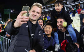 Sam Cane of New Zealand takes selfies with fans during the 2023 Rugby Championship match between the New Zealand All Blacks and South Africa at Go Media Mount Smart Stadium in Auckland, New Zealand on Saturday July 15, 2023