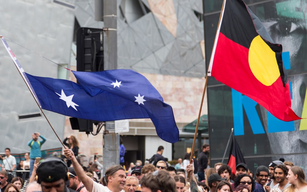 Protestors wave the Australian Flag with the Union Jack cut out and an Aboriginal Flag, during a protest, organized by Aboriginal rights activists on Australia Day in Melbourne,