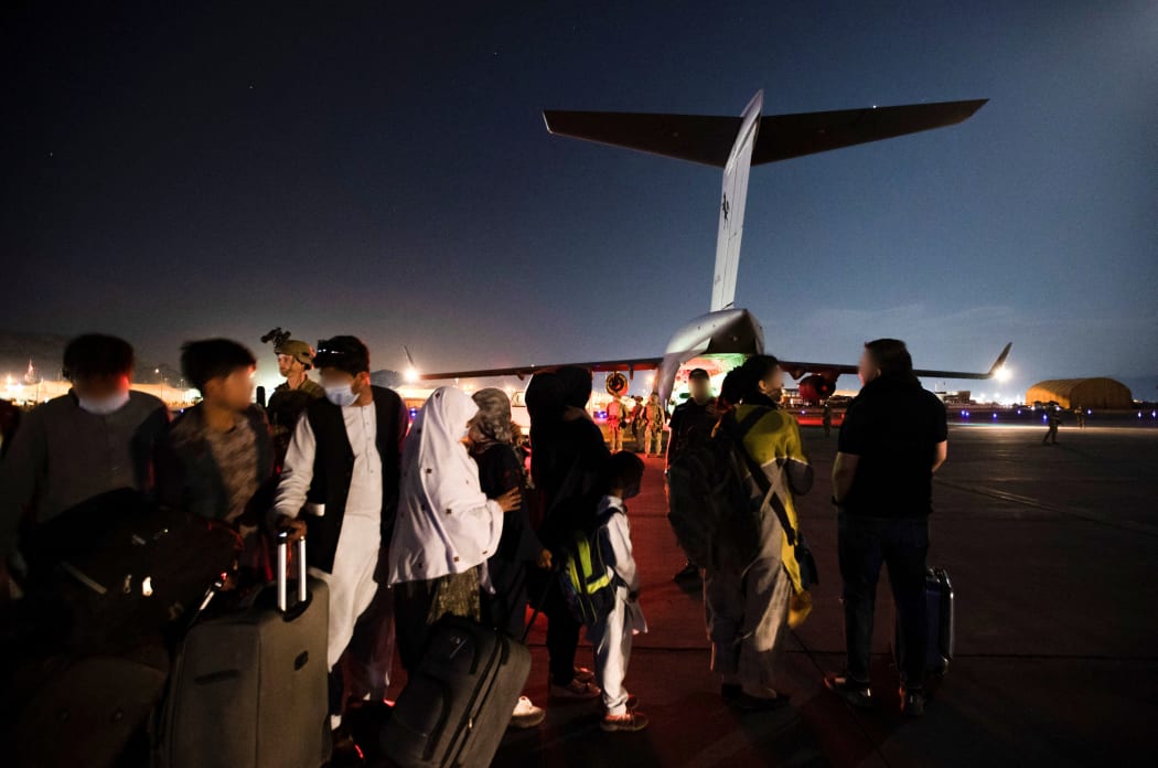 Ppeople forming a line to board the Royal Australian Air Force C-17A Globemaster at Hamid Karzai International Airport in Kabul.