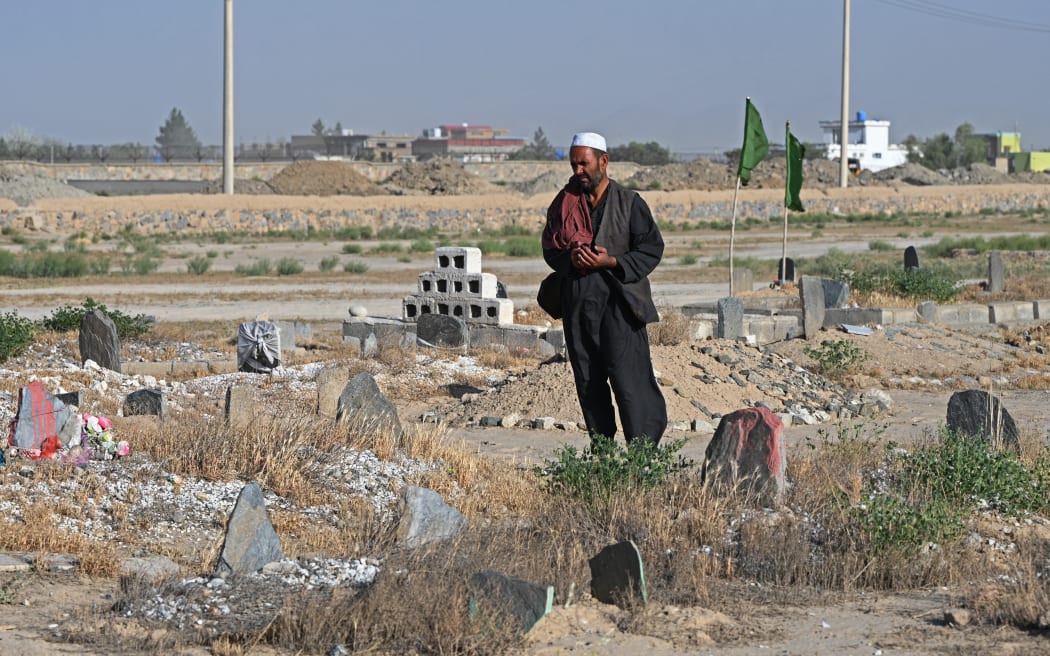 Gul Ajan Hotak offers prayers over the grave of his late son Shafiullah Hotak, who died after falling from a US Air Force C-17 aircraft in August 2021 in Kabul.