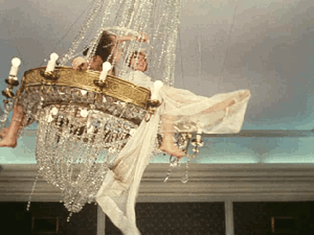 a gif of two people swinging on a chandelier