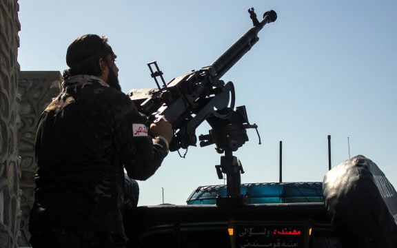 A Taliban security personnel manning a gun sits in the back of a vehicle amid the ongoing clashes between Afghanistan and Pakistani forces in the Momand Dara district of Nangarhar province on March 13, 2026. Afghan authorities said on March 13 that Pakistan attacks on Kabul and border provinces killed four people in the capital and two in the east, the latest deadly clashes in the long-running conflict. (Photo by AFP)