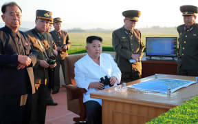 This undated picture released from North Korea's official Korean Central News Agency shows North Korean leader Kim Jong-Un (C) inspecting the test of a new anti-aircraft guided weapon system organized by the Academy of National Defence Science at an undisclosed location.