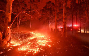 Burning embers cover the ground as firefighters battle against bushfires around the town of Nowra in the Australian state of New South Wales on December 31, 2019.