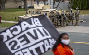 Minnesota National Guard and law enforcement members stand guard outside the Brooklyn Center Police Station after a police officer shot and killed a Black man in Brooklyn Center, Minneapolis, Minnesota on April 12, 2021.