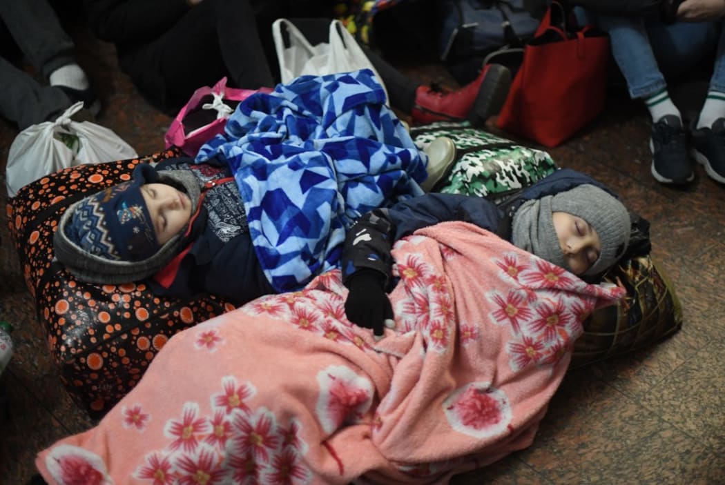 Children are sleeping on the floor at Lviv central train station in Western Ukraine on February 26, 2022.