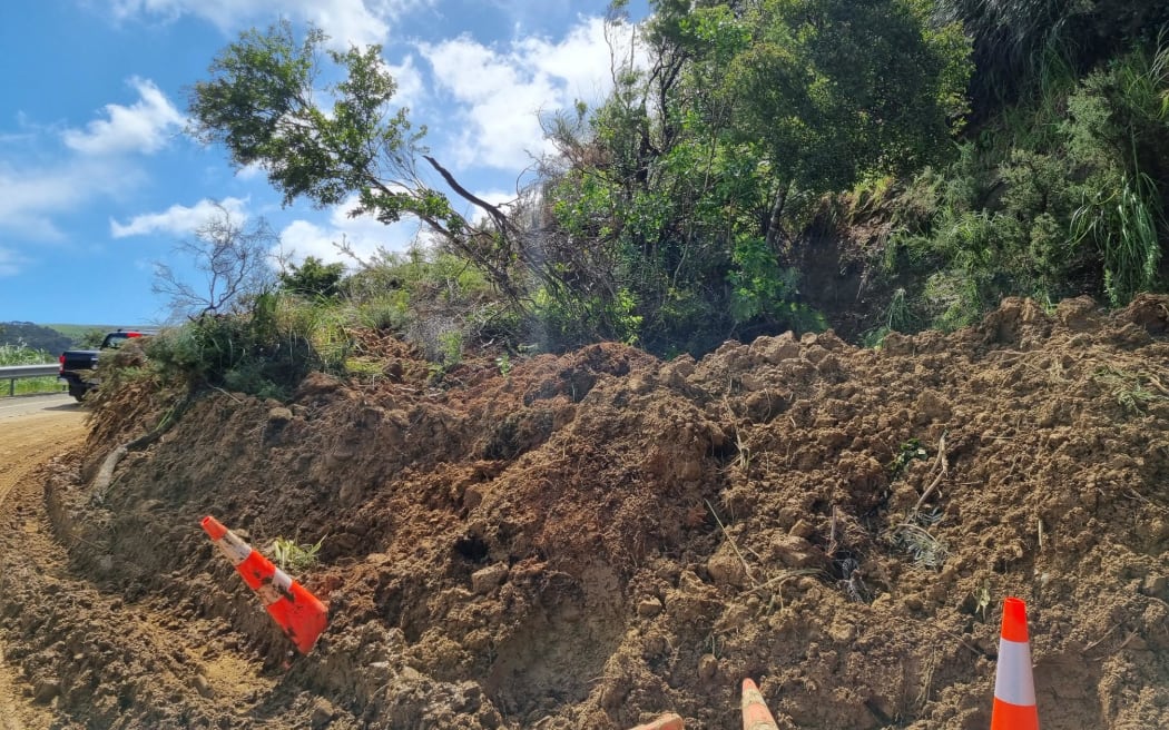 More than a hundred vehicles backed up on Matakana Valley Road, where a large slip is blocking one lane. The police were on-site at the Auckland region road, which is one of two routes between the towns of Wellsford and Leigh.