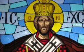 Christ depicted as a king with a crown. Stained glass window.