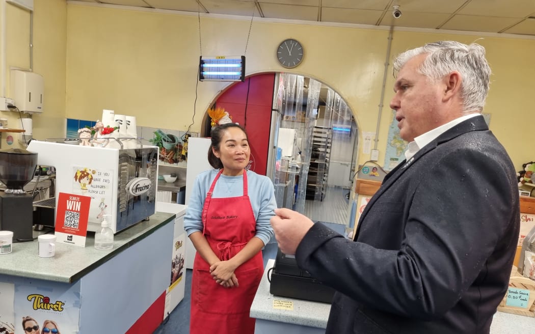 Goldiluck Bakery owner Renneth Thongly speaks with Police Minister Mark Mitchell about the effects of having police on the streets.