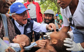 The WHO's Regional Director for the Pacific, Dr Shin Young-soo provides oral polio vaccine in Lae in Morobe
