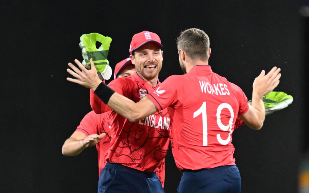 Jos Buttler (left) and Chris Woakes (right) of England celebrate a wicket