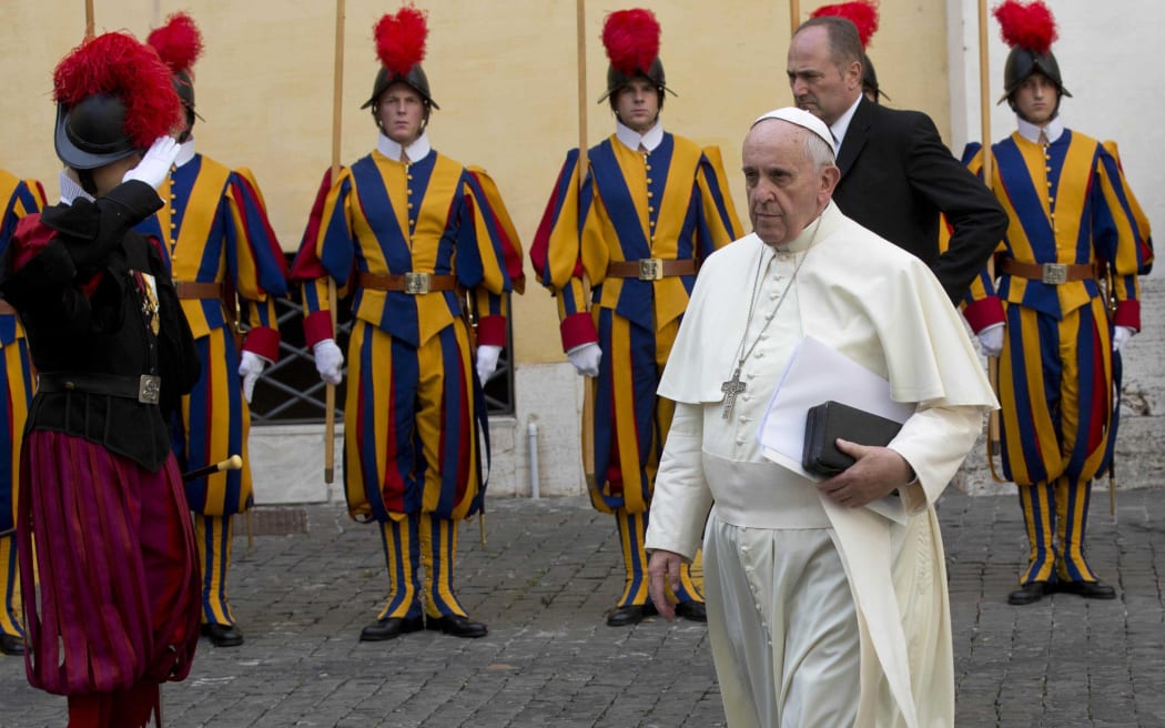 Pope Francis walks past Swiss guards at the Vatican.