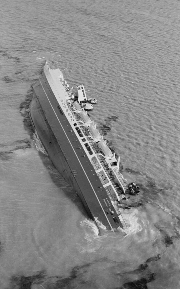 Aerial view of the inter-island ferry, Wahine, lying on her side in Wellington Harbour. Photograph taken 11 April 1968 by an Evening Post staff photographer.