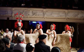 McAuley High School students gifting a Ie Toga or fine mat during the formal part of the Dawn Raids apology.