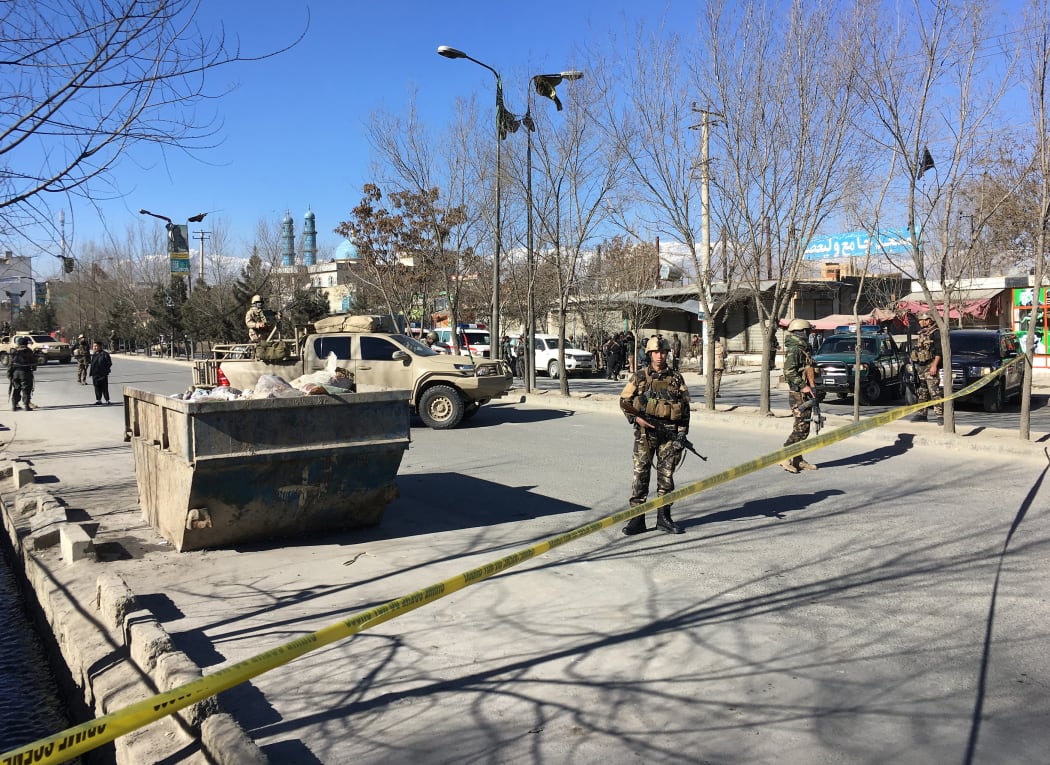 Afghan security forces stand guard near the site of multiple blasts in Kabul on December 28.