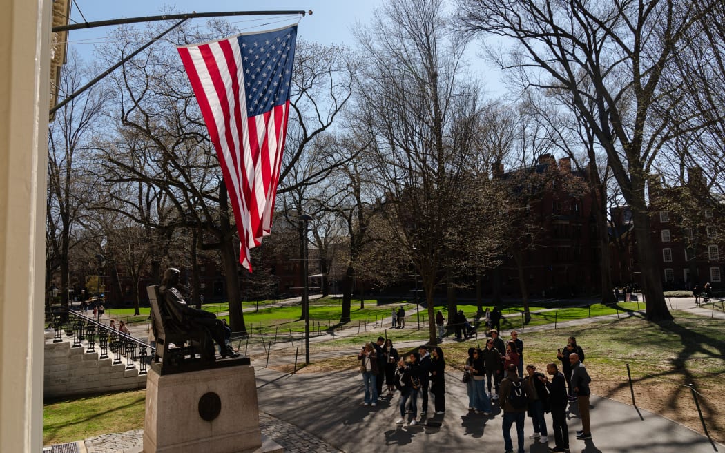 CAMBRIDGE, MASSACHUSETTS - APRIL 17: People gather to take photos with the John Harvard Statue at Harvard University on April 17, 2025 in Cambridge, Massachusetts. The Trump administration announced that it would block Harvard University from receiving $2.2 billion in federal grants and $60 million in contracts after the school refused demands to adopt new policies relating to student and faculty conduct, admissions, anti-semitism on campus and DEI.   Sophie Park/Getty Images/AFP (Photo by Sophie Park / GETTY IMAGES NORTH AMERICA / Getty Images via AFP)