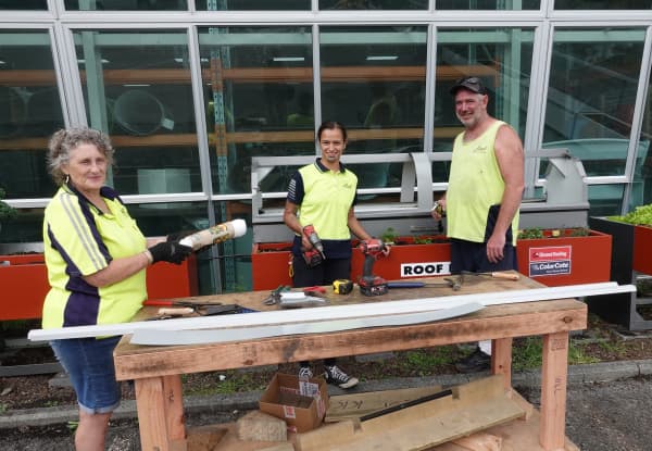 Tracy Moore, Nike Rosenthal and Rick Harper work on a raised planter made from surplus roofing steel.