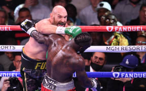 WBC heavyweight champion Tyson Fury of Great Britain (L) lands a punch on US challenger Deontay Wilder (R) during a fight for the WBC/Lineal Heavyweight title at the T-Mobile Arena in Las Vegas, Nevada, October 9, 2021. (Photo by Robyn Beck / AFP)