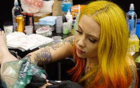 New York tattooist Megan Massacre works on a client.