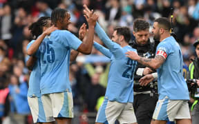 Manchester City's Portuguese midfielder #20 Bernardo Silva (centre right) celebrates with teammates on the pitch after the English FA Cup semi-final football match between Manchester City and Chelsea at Wembley Stadium in north west London on April 20, 2024. Manchester City won the game 1-0. (Photo by Glyn KIRK / AFP) / NOT FOR MARKETING OR ADVERTISING USE / RESTRICTED TO EDITORIAL USE