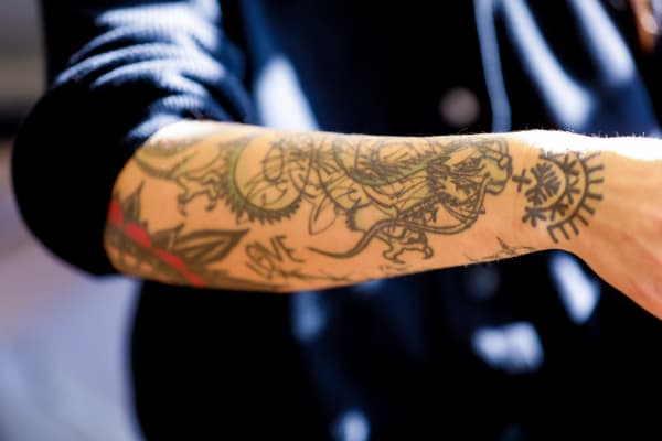 Alma Proença shows her forearm which has a dragon tattoo.