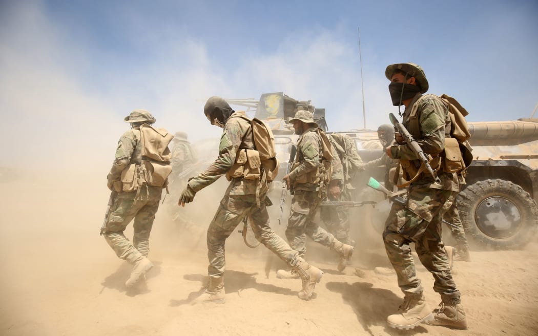 Iraqi government forces advance near al-Sejar village, north-east of Falluja, on 26 May 2016.