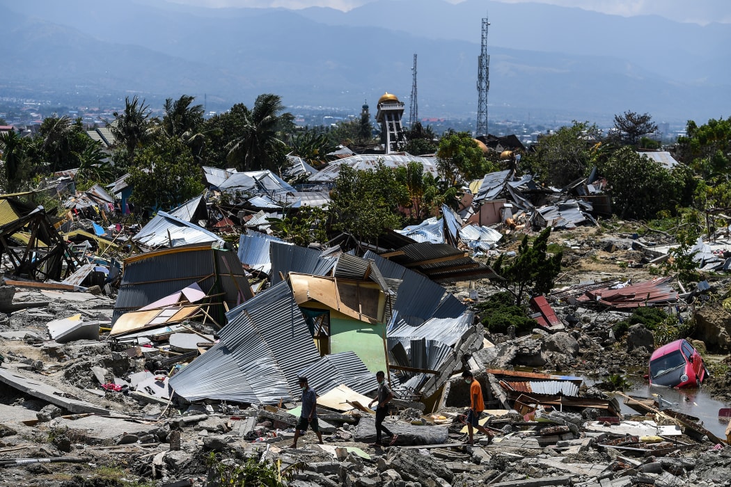 Residents walk past destroyed buildings in the Perumnas Balaroa village in Palu, after an earthquake and tsunami hit the area.