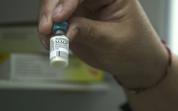 Dr Richard Hulme holding Measles Vaccine
