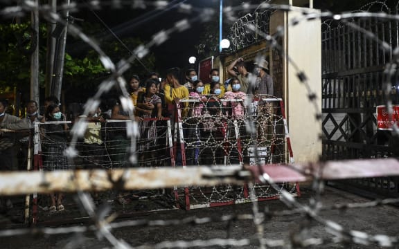 People wait outside the Insein Prison in Yangon on October 18, 2021, as authorities announced more than 5000 people jailed for protesting against a February coup which ousted the civilian government would be released.