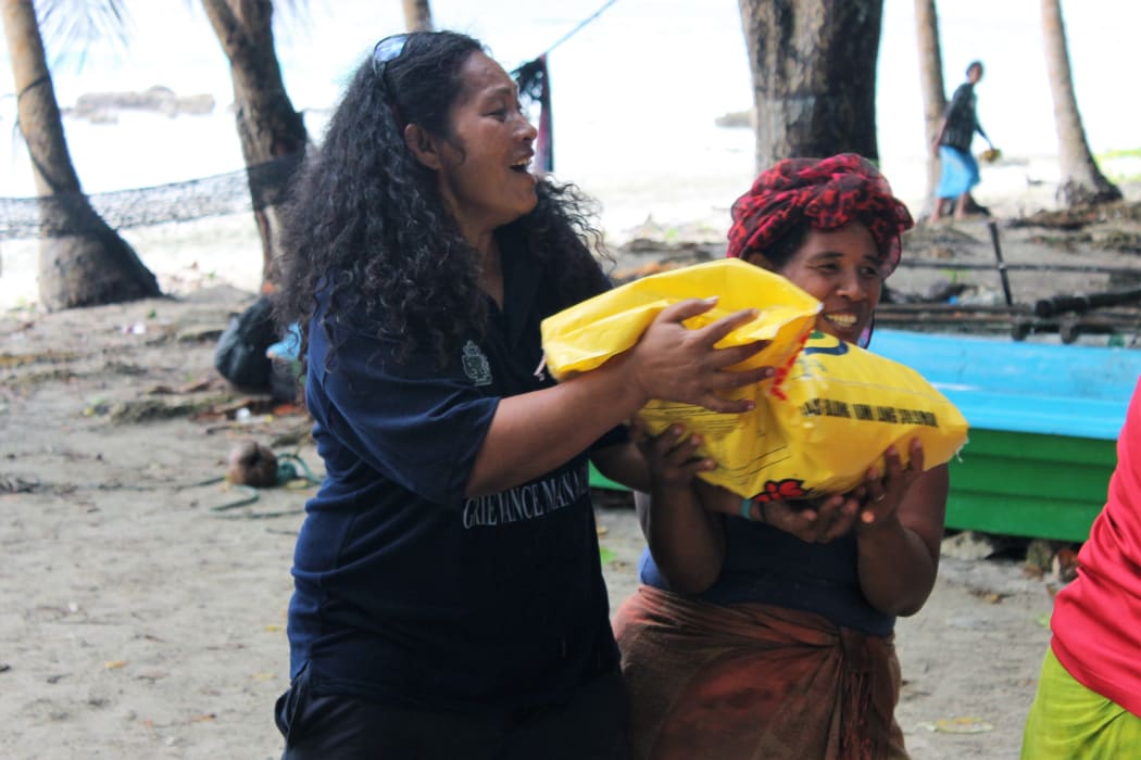 Community Officer Jennifer Tai (left) unloading supplies, Bellona, Solomon Islands.