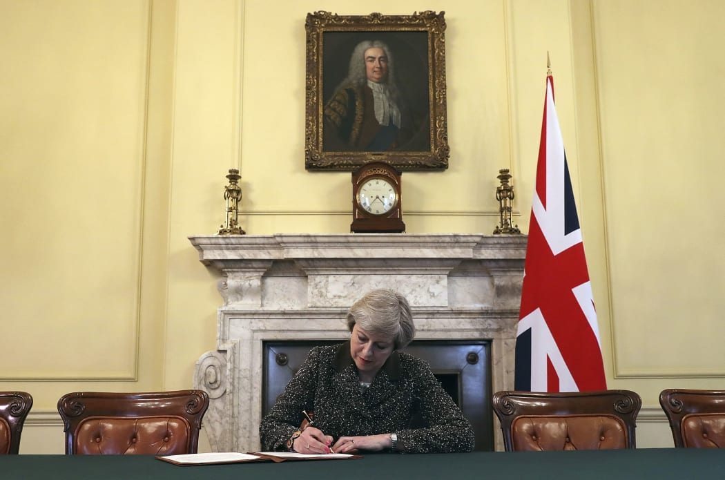 FILE - In this Tuesday March 28, 2017 file photo Britain's Prime Minister Theresa May, sitting below a painting of Britain's first Prime Minister Robert Walpole,