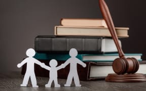 Paper people chain, books and judge's gavel. Law, family politics and gay marriage legalization.