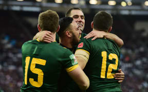 Valentine Holmes (centre) celebrates a try with his Australian teammates.