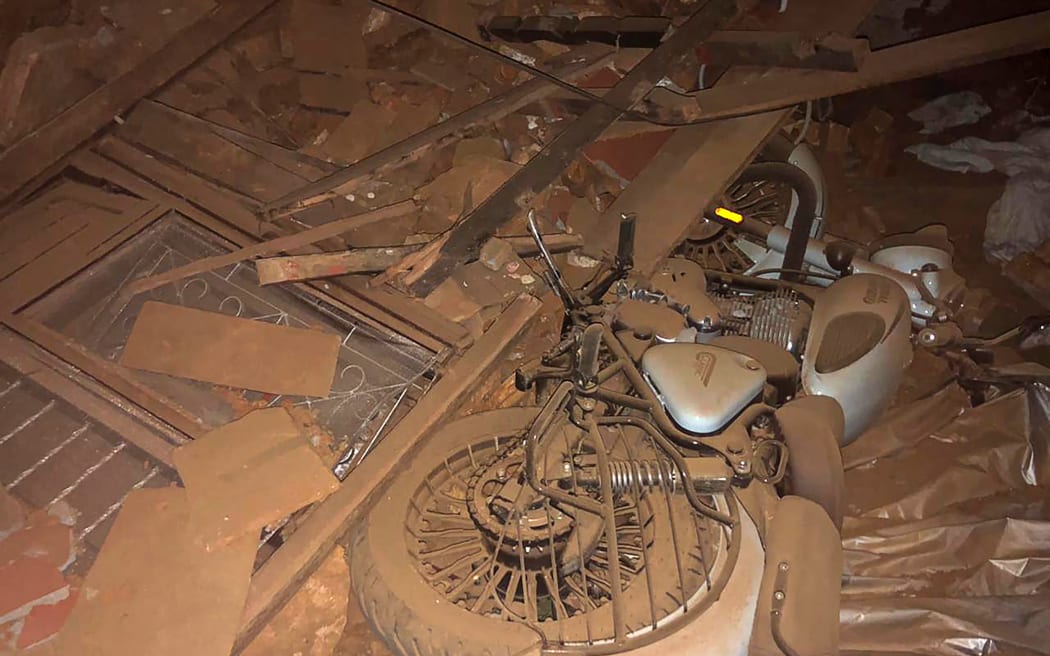 A motorcycle and broken windows are seen in the midst of the rubble in the aftermath of an earthquake in Jajarkot on November 4, 2023. More than 60 people were killed when a shallow 5.6-magnitude earthquake hit a remote pocket of Nepal, officials said early on November 4. The tremor hit the far west of the Himalayan country late Friday and was measured by the US Geological Survey at just 18 kilometres (11 miles) deep. (Photo by Balkumar Sharma / AFP)