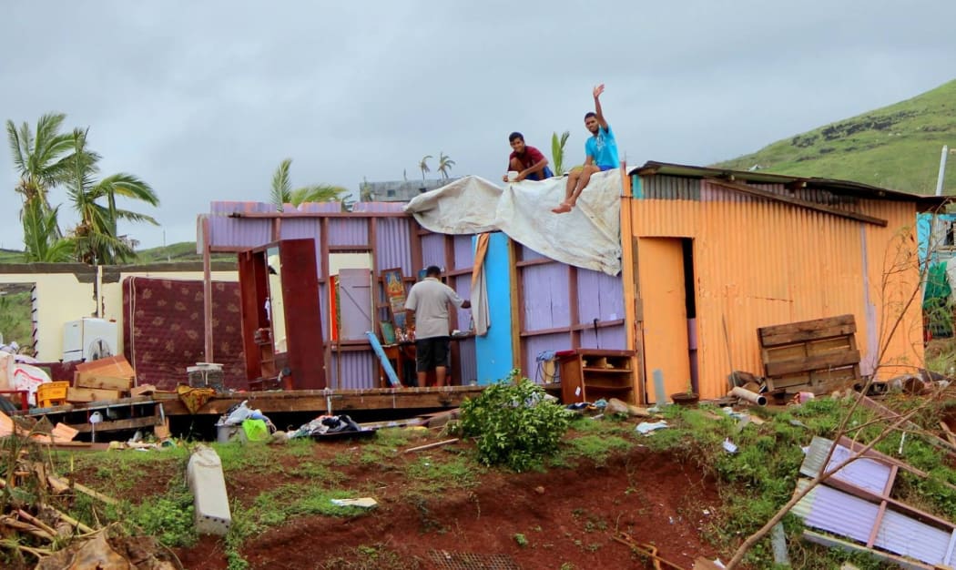 Locals wave from a damaged house in Rakiraki, Fiji, after Cyclone Winston.