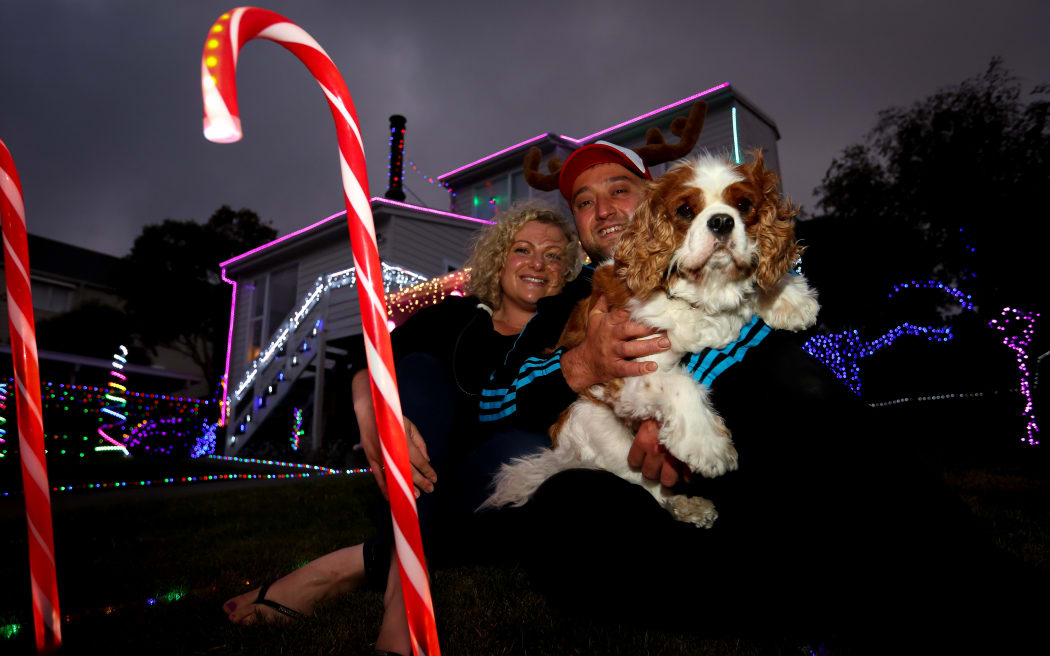 Laura and Sargoon Yousif with their dog, Ollie, outside their festive home.