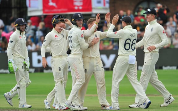 Joe Root (capt) of England high fives Dominic Bess of England.