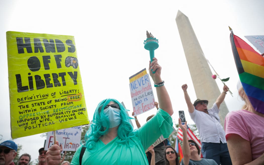 WASHINGTON, DC - APRIL 19: Participants in the Anti-Trump protest shout and hold up signs on April 19, 2025 in Washington, DC. Organizers of the nationwide protest said the demonstrations were to denounce the "hostile government takeover" by the Trump administration.   Kayla Bartkowski/Getty Images/AFP (Photo by Kayla Bartkowski / GETTY IMAGES NORTH AMERICA / Getty Images via AFP)
