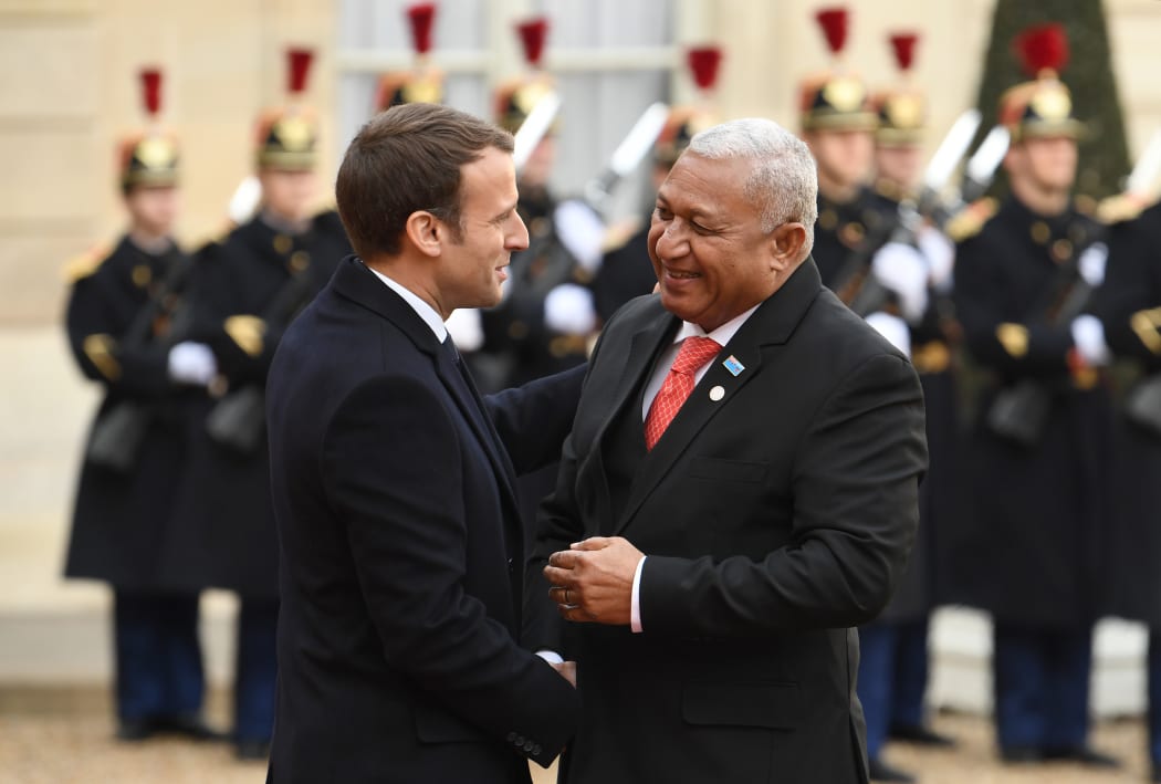 French President Emmanuel Macron (L) greets Prime Minister of Fiji Frank Bainimarama as he arrives at the the One Planet Summit.
