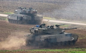 A picture taken in southern Israel near the border with the Gaza Strip on December 7, 2023, shows Israeli army tanks manoeuvring amid continuing battles between Israel and the militant group Hamas.  (Photo by Menahem KAHANA / AFP)