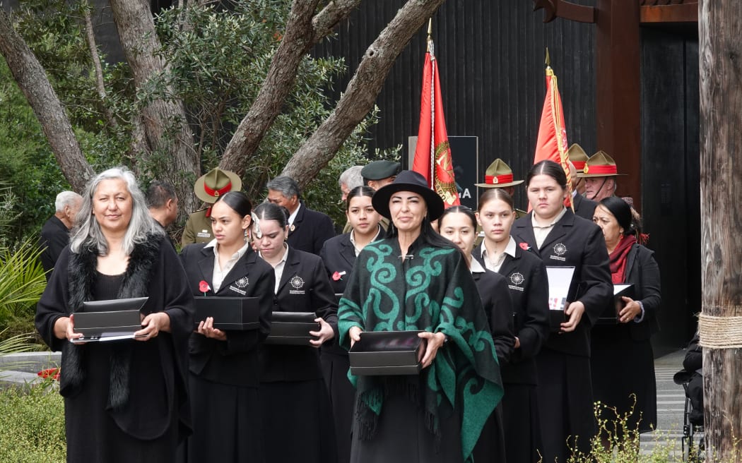 Some of the medals are carried from Te Rau Aroha, the Museum of the Price of Citizenship, to Te Whare Rūnanga [the carved meeting house].