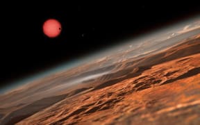 An artist’s impression showing the possible view from the surface one of the three planets orbiting an ultracool dwarf star just 40 light-years from Earth.