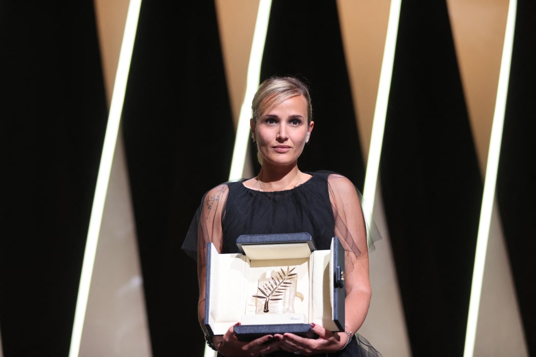 French director Julia Ducournau poses on stage with her trophy after she won the Palme d'Or for her film Titane at the Cannes Film Festival.