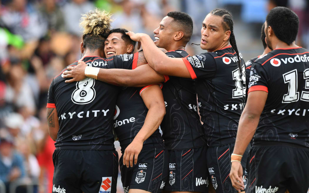 Warrior's captain Roger Tuivasa-Sheck celebrates his try with team mates.