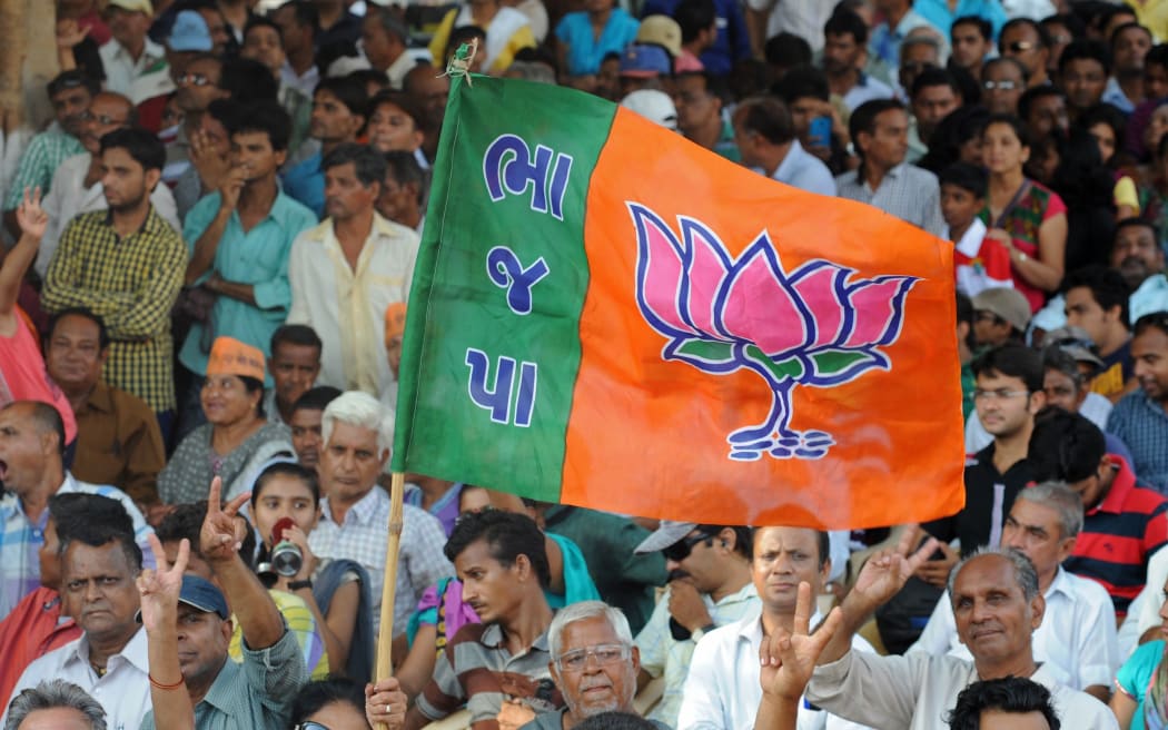 BJP supporters wave the party flag during Narendra Modi's rally.
