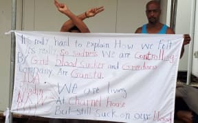 Bashir Osman displays one of his protest banners.
