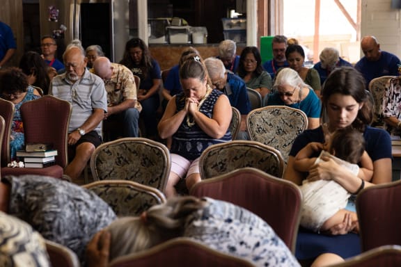 Survivors and churchgoers pray during a church service held by Pastor Brown of Lahaina's Grace Baptist Church, in Wailuku, central Maui.