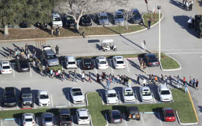 People are brought out of Marjory Stoneman Douglas High School after the shooting at the school that reportedly killed and injured multiple people.