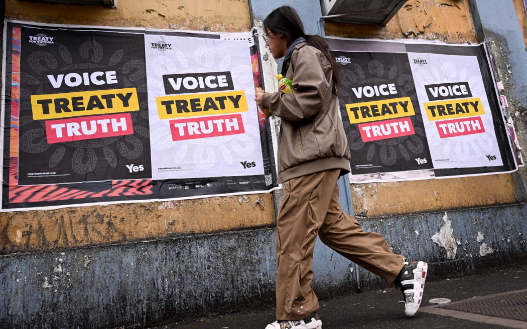 A woman walks past posters advocating for an Aboriginal voice and treaty ahead of an upcoming referendum, in Melbourne on August 30, 2023. Prime Minister Anthony Albanese announced Australia will hold a historic Indigenous rights referendum on October 14 setting up a defining moment in the nation's relationship with its Aboriginal minority. (Photo by William WEST / AFP)